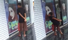 Seorang pria menciumi foto banner salon