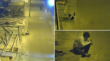 Seorang anak kerjakan PR di pinggir jalan