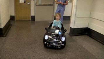 Pasien anak menaiki mobil mainan ke ruang operasi