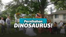 Pengiring pengantin memakai kostum t-rex