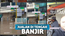 Tukang gorengan jualan di tengah banjir