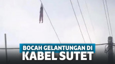 Bocah bergelantung di kabel sutet