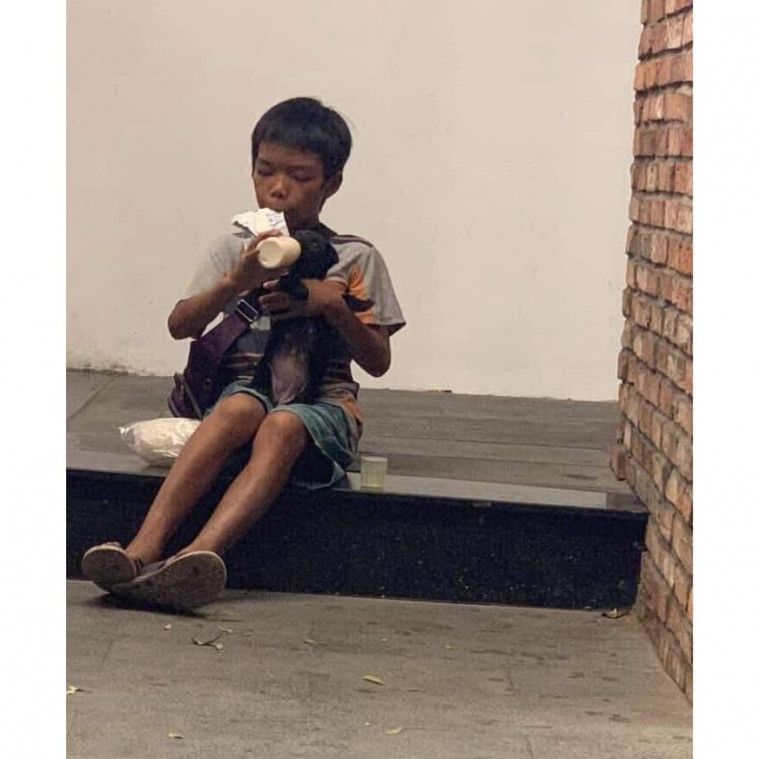 Dari hasil tukang parkirnya, anak ini membeli susu saset lalu ia berikan ke seekor anjing jalanan.