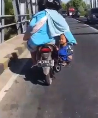 posisi jongkok anak diletakkan di keranjang samping motor