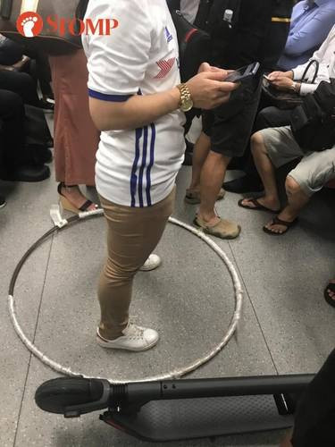Memakai hula hoop di MRT