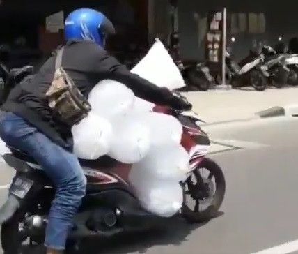 gaya pria bawa banyak es pake motor