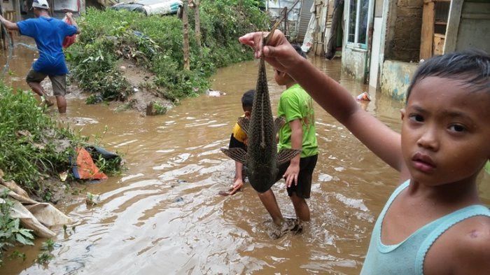 Bocah memancing saat banjir